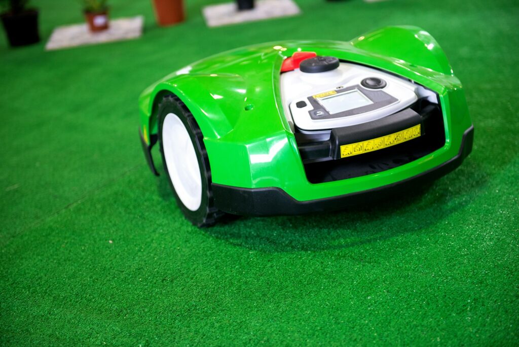 a robotic lawn mower working on a green grass field