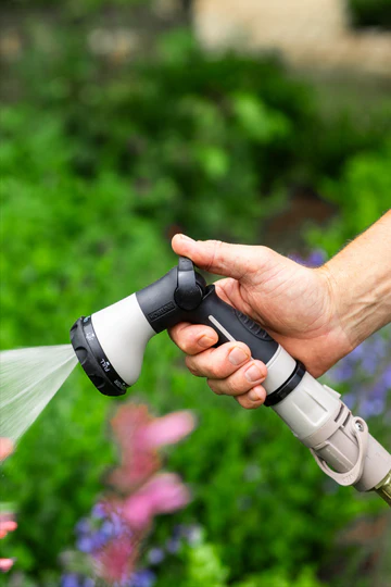 A garden hose with a spray nozzle featuring a comfort grip and multiple spray patterns.