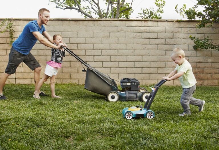 family mowing lawn in the backyard