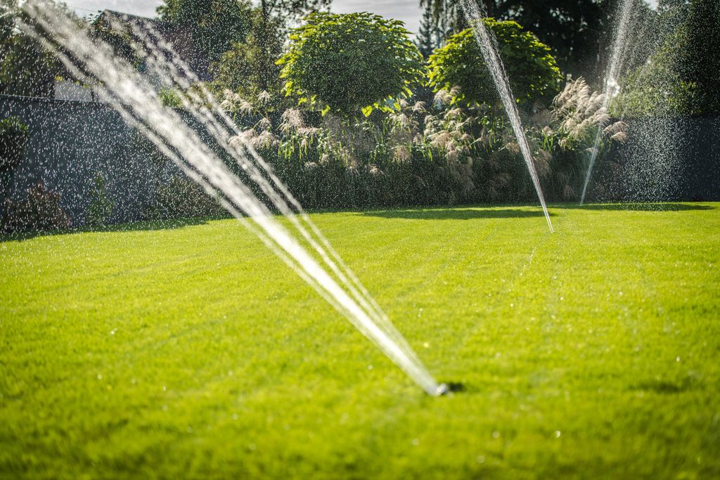 A lawn irrigation system in operation, with multiple sprinklers.