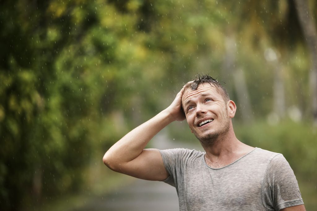 man enjoying heavy rain