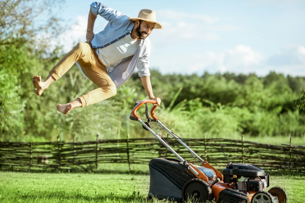 Man with lawn mower on the backyard