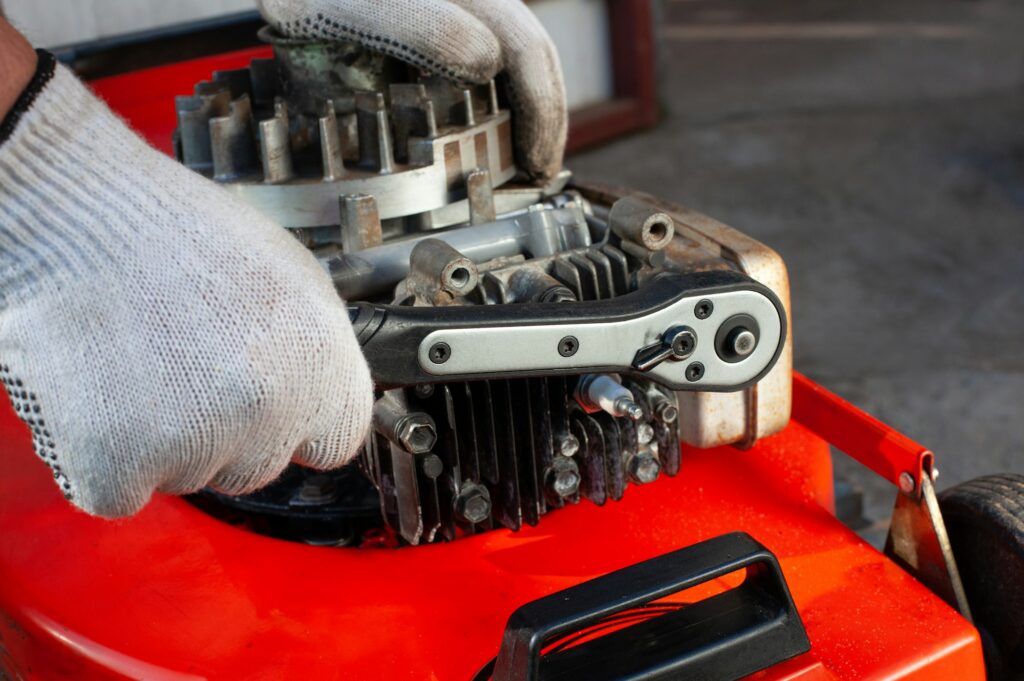 Repairing the mower in the garage.